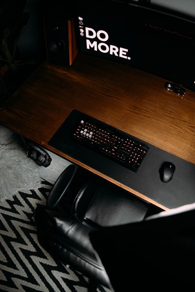 棕色木桌上的黑色电脑键盘